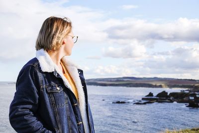 Woman looking at sea against sky