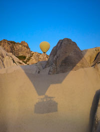 View of hot air balloons in desert against blue sky