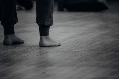 Low section of woman standing on wooden floor