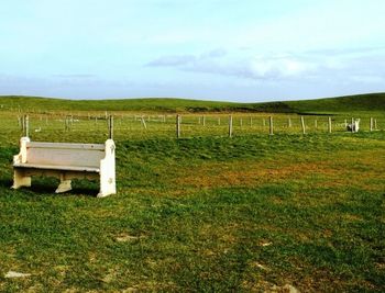 Scenic view of grassy field against cloudy sky