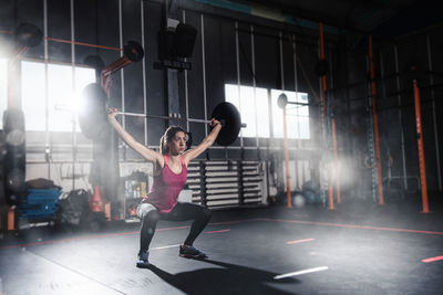 Full length of woman exercising in gym