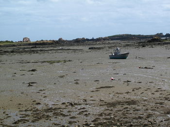 Scenic view of beach against cloudy sky