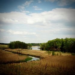 Scenic view of river against cloudy sky