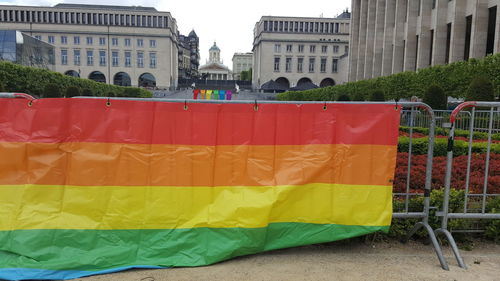 Multi colored flags in city against sky