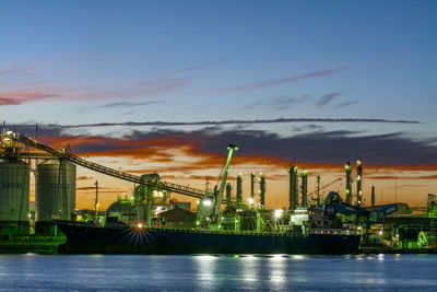 View of factory by sea against sky