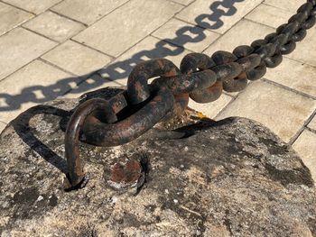 High angle view of rusty chain on rock