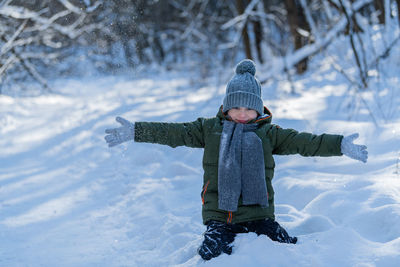 Portrait of boy playing on snow covered land