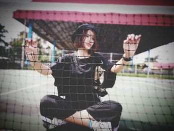 Thoughtful woman sitting by net in court