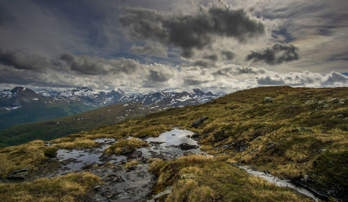 Scenic view of mountains against cloudy sky