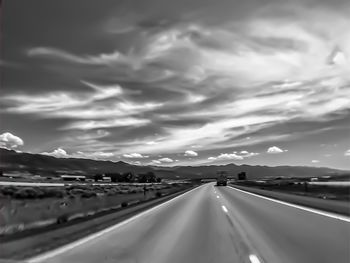 Country road against cloudy sky