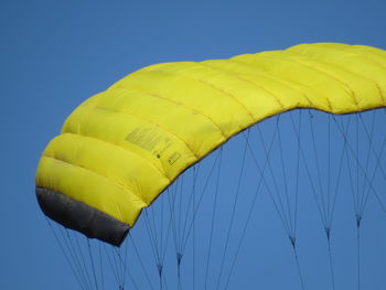 Low angle view of yellow parachute against clear sky