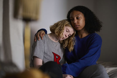 Young woman comforting crying friend