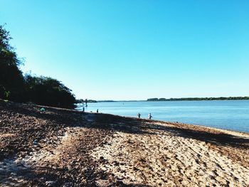 Scenic view of beach against clear blue sky