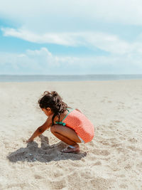 Rear view of woman sitting at beach