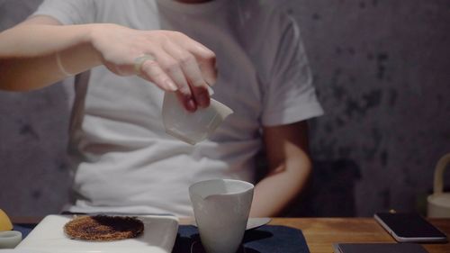 Midsection of man holding tea cup