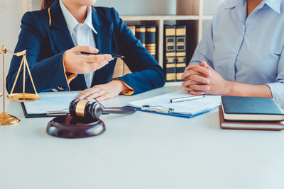 Midsection of man holding umbrella on table