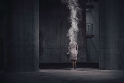 Rear view of woman standing against wall