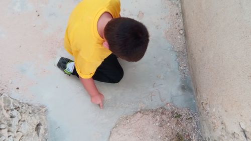 Rear view of boy standing on sand at beach