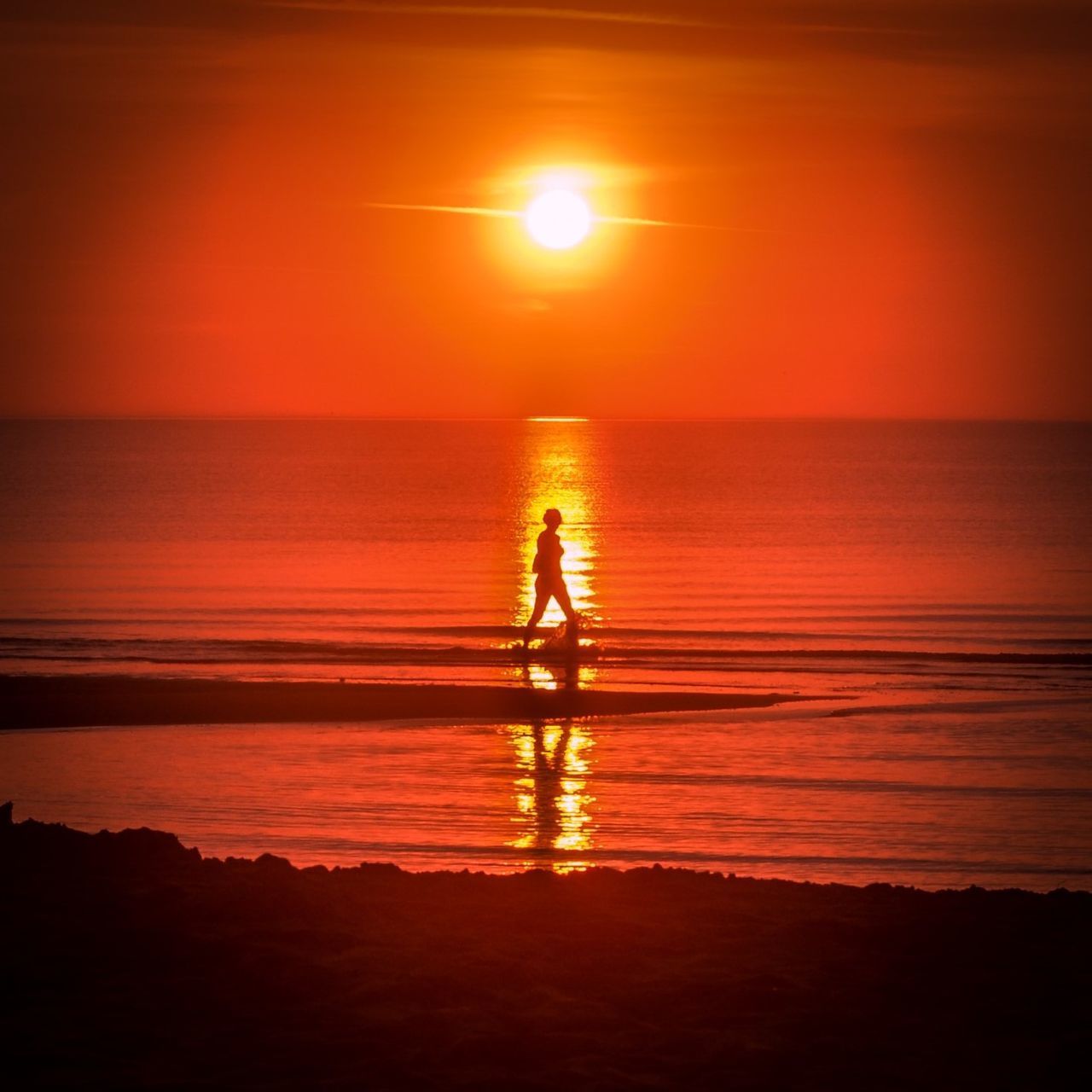 SILHOUETTE PERSON ON SHORE AGAINST SUNSET SKY