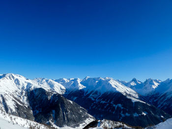 Scenic view of snowcapped mountains against clear blue sky