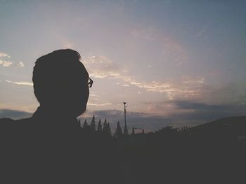 Silhouette woman against sky during sunset