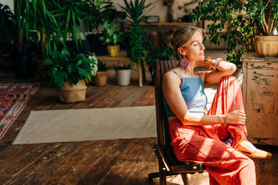 Young gorgeous woman sitting on a chair near the window