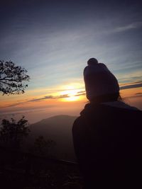 Silhouette of man on landscape against sky during sunset