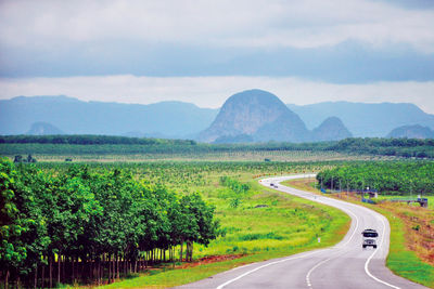 Empty road along landscape against sky