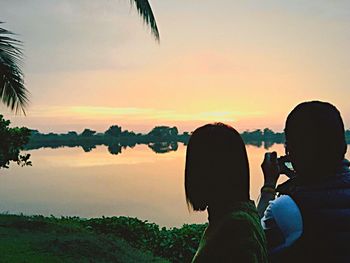 People photographing against sky during sunset