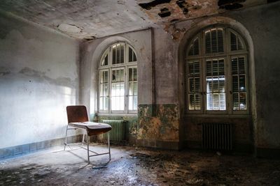 Empty chair and table in abandoned room