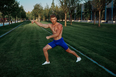 Full length of woman exercising on field