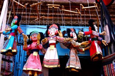 Low angle view of puppets hanging against house