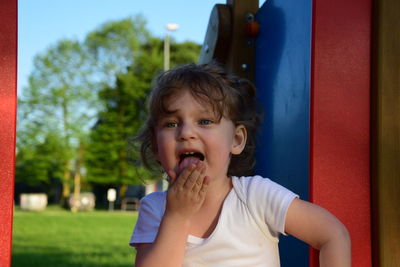 Girl licking palm while playing on playground