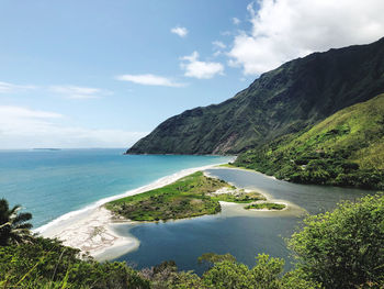 Scenic view of sea and mountains against sky