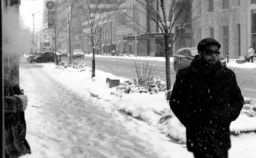 Woman on snow covered street in city