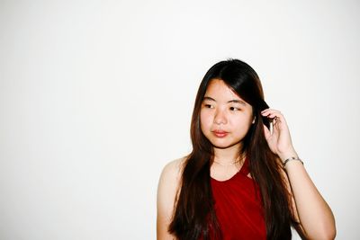 Portrait of beautiful young woman against white background