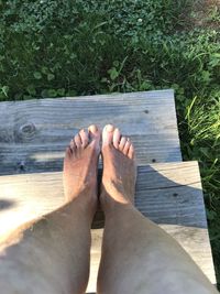 Low section of man relaxing on wood