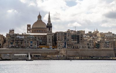 Buildings in city against cloudy sky