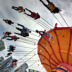 Low angle view of people enjoying chain swing ride at navy pier