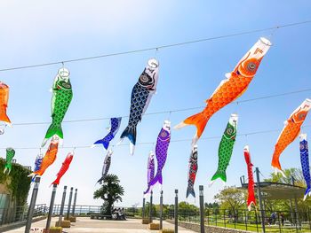 Low angle view of multi colored flags hanging against sky