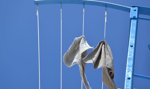 Low angle view of clothes drying against clear blue sky