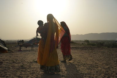 Desert folks of the musician caste are walking through the desert in pushkar, india