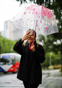 Rear view of woman holding umbrella