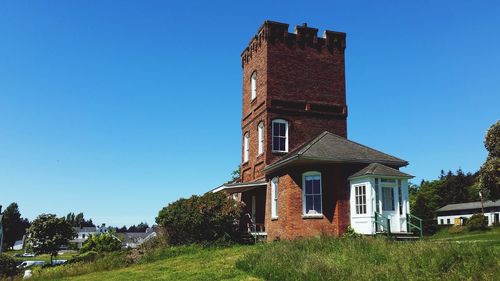 Low angle view of old building against clear blue sky