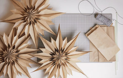 Top view of diy 3d snowflake with brown paper lunch bags, craft christmas paper decoration, tutorial