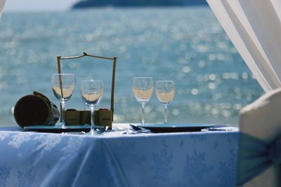 Wineglasses on table against lake