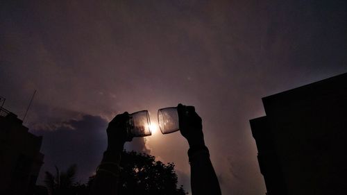 Low angle view of illuminated buildings against sky at night