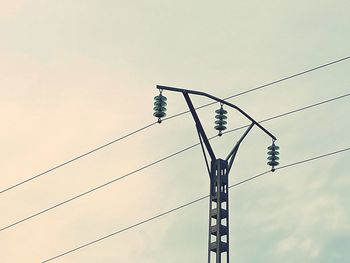 Low angle view of electricity pylon against sky