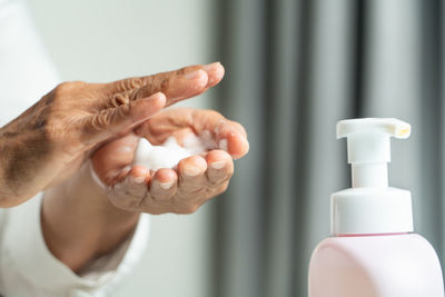 Close-up of hand holding white bottle