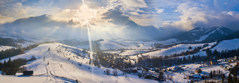 Panoramic view of snow covered mountains against sky